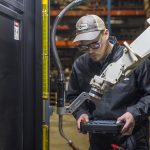 Welder using a teach pendant to program a welding robot